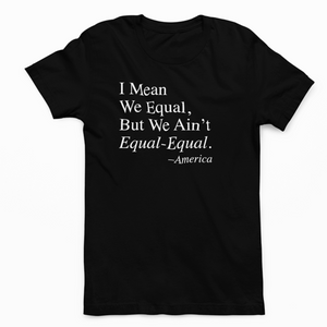 A black ROCKaBLOCK statement t-shirt with the quote "I mean we equa, but we ain't equal-equal' on it, standing outdoors.
