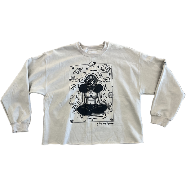 ROCKaBLOCK “Give Me Space” raw hem crewneck sweatshirt in tan, featuring a bold black illustration of a meditating woman in an astronaut helmet surrounded by planets and stars.