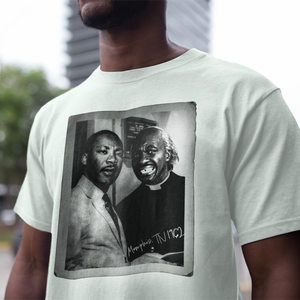 A man wearing a ROCKaBLOCK "I Met Dr. King" graphic tee featuring marting Luther King Jr.  and  Cearance the barber from Coming to America.