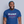 Load image into Gallery viewer, A man smiling and wearing a blue ROCKaBLOCK graphic tee with the text &#39;RUMP SHAKER WRECKX-N-EFFECT 1992&#39; printed on the front.
