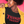 Load image into Gallery viewer, Black woman wearing a ROCKaBLOCK black t-shirt with &#39;THANGIN THANGS&#39; text in red, yellow jacket, and striped pants against a pink background.
